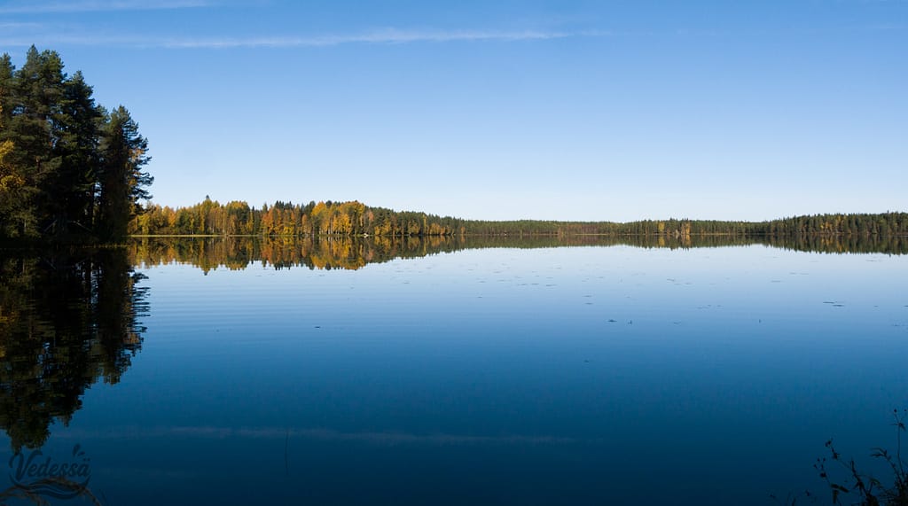 Kuva jossa on tyyni järvimaisema.
